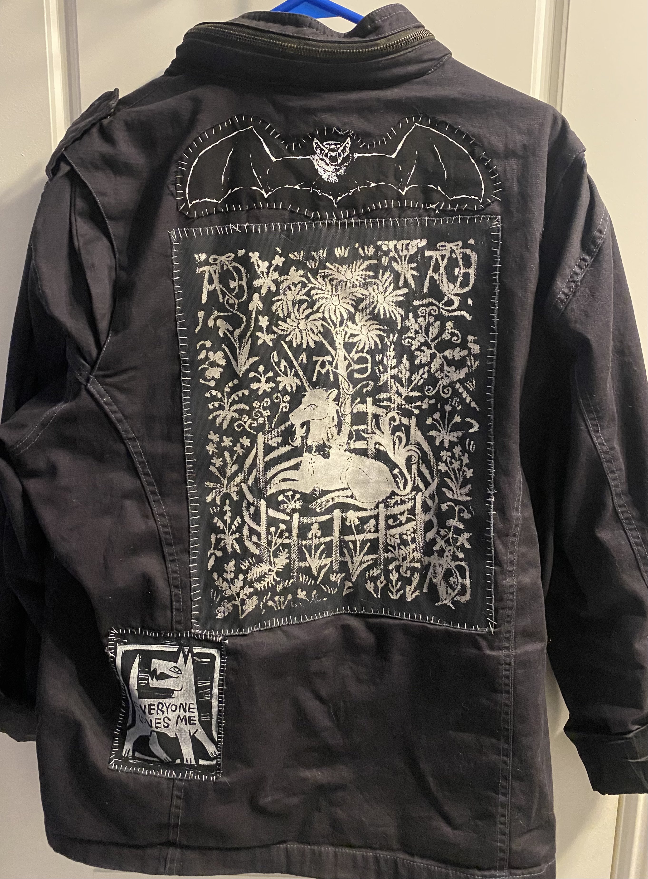 The back of a black jacket with a few hand-sewn patches