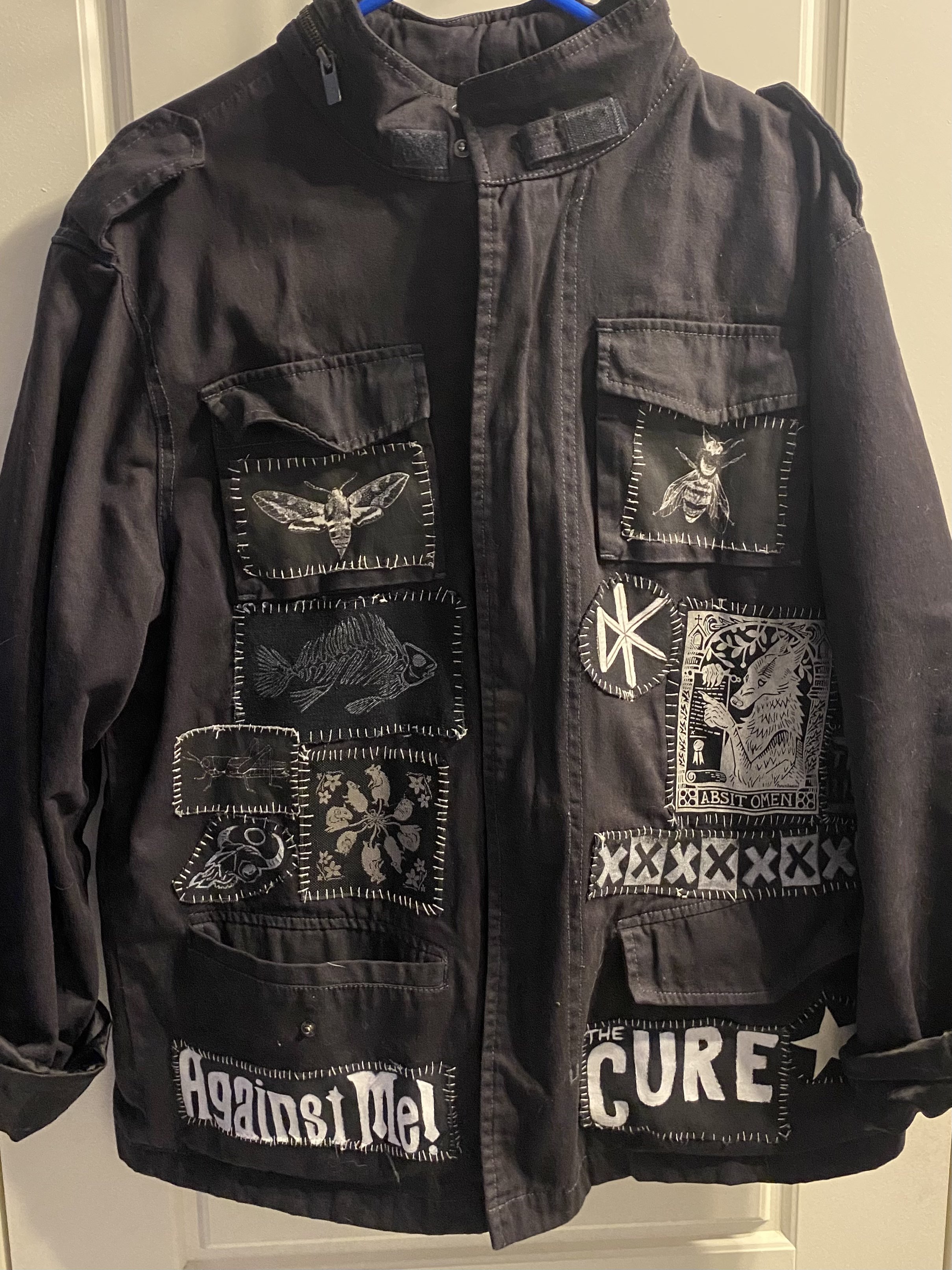 The front of a black jacket with several hand-sewn patches
